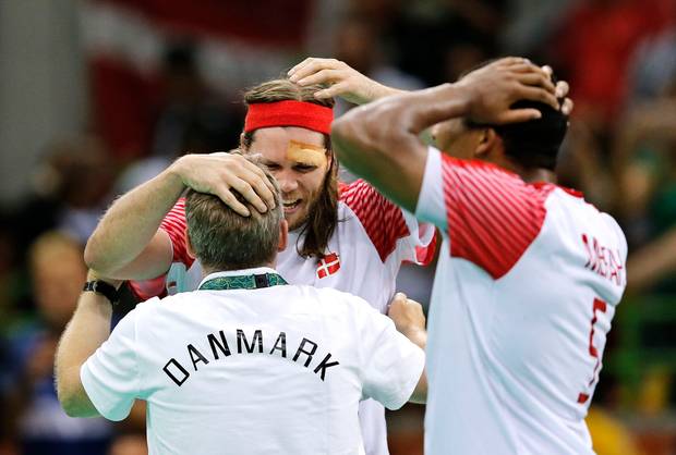 Landstræner Gudmundur Gudmundsson og Mikkel Hansen krammer med Mads Mensah Larsen som tilskuer. Foto: Jens Dresling/Polfoto