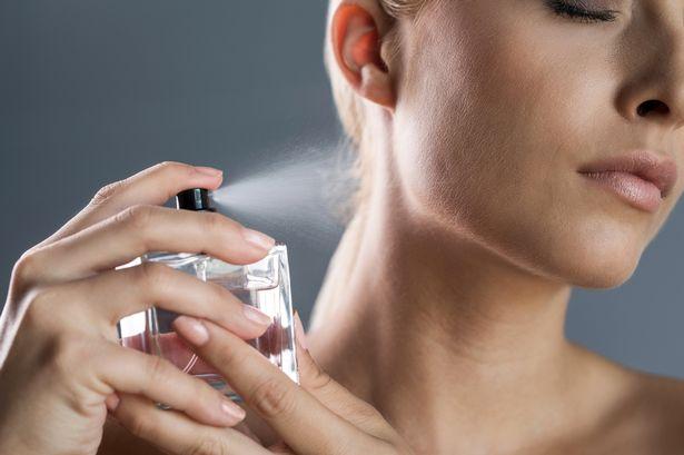 Close-up-of-a-woman-spraying-perfume-on-
